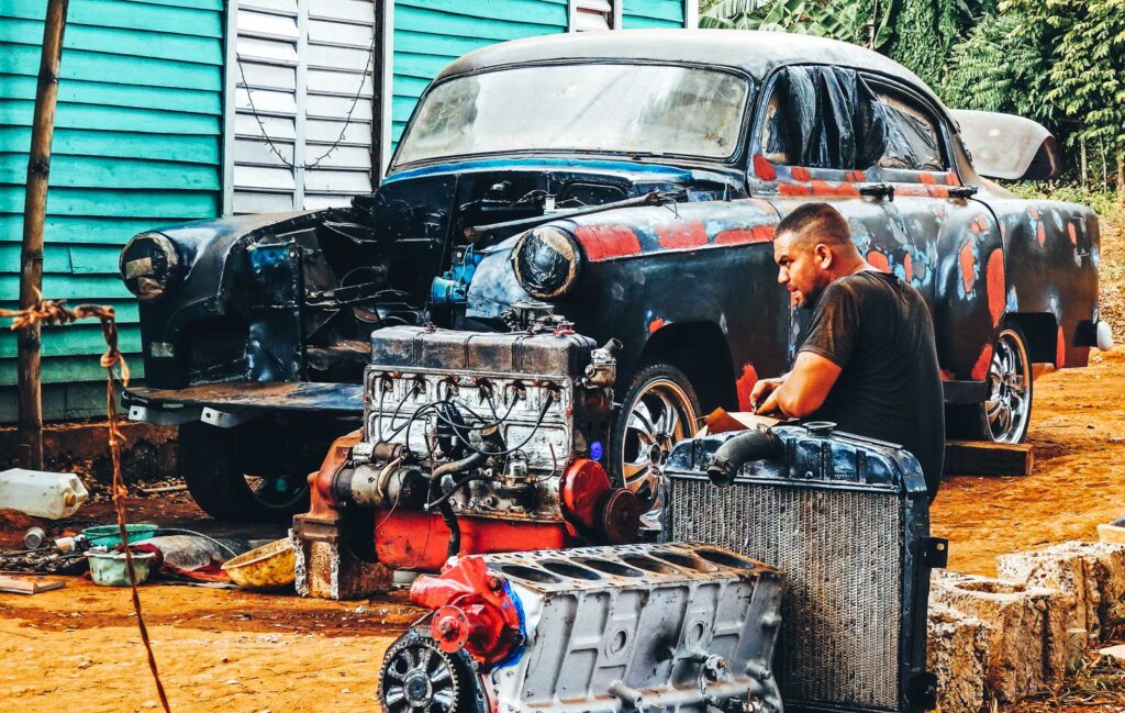 One awesome reason to backpack Vinales. A Cuban man fixes his car in the front garden